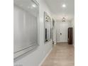 Bright hallway features wood-look floors, recessed lighting, and a decorative mirror at 6156 Ava Ridge Ave, Las Vegas, NV 89141