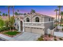 Two-story home featuring a three-car garage, arched windows, and desert landscaping at 62 Incline Village Ct, Henderson, NV 89074