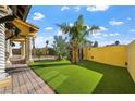 Private backyard featuring a green lawn, desert landscaping and stucco wall with privacy at 6760 Hinson St, Las Vegas, NV 89118