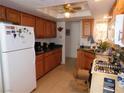 Functional kitchen featuring tile flooring, oak cabinetry, black countertops, and modern appliances at 710 Strawberry Pl, Henderson, NV 89002