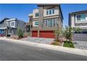 Modern three-story home with clean lines, a balcony, and a red two-car garage at 7180 Grace Estate Ave, Las Vegas, NV 89113