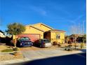 Beautiful home with a red garage door, desert landscaping, and two cars parked out front at 7910 Shimmery St, North Las Vegas, NV 89084