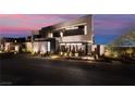 A modern home exterior showcasing its unique architectural design and front landscaping against a colorful sky at 801 Dragons Eye Dr, Henderson, NV 89012