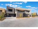 Contemporary home with a gray exterior, attached garage, and minimalist front yard landscaping at 801 Dragons Eye Dr, Henderson, NV 89012