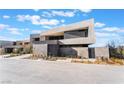 Modern home featuring a geometrically designed facade, a sleek stone wall, and desert landscaping at 801 Dragons Eye Dr, Henderson, NV 89012