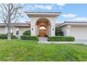 Inviting home with arched entryway, manicured hedges, and a lush green lawn at 8701 Robinson Ridge Dr, Las Vegas, NV 89117