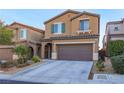 Two-story home featuring a 2-car garage, desert landscaping, and a charming, covered front entryway at 10139 Palazzo Marcelli Ct, Las Vegas, NV 89147