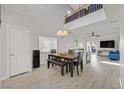 Bright dining area with wood floors, a view of the loft, and a modern light fixture at 1646 Little Crow Ave, Las Vegas, NV 89123