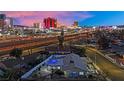 Aerial view of home with pool, showcasing a city skyline backdrop against a twilight sky at 1805 Ivanhoe Way, Las Vegas, NV 89102