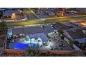 Aerial view of a home with a backyard featuring a uniquely shaped pool illuminated with bright blue light at twilight at 1805 Ivanhoe Way, Las Vegas, NV 89102