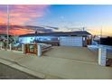 A single-story house features a well-kept front yard, a driveway leading to an attached garage against a stunning sunset at 1805 Ivanhoe Way, Las Vegas, NV 89102