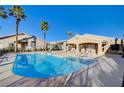 Resort-style community pool with lounge chairs and palm trees under a blue sky at 209 Roxborough St, Henderson, NV 89074