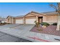 Inviting single-story home with a two-car garage, landscaped yard, and desert rock at 209 Roxborough St, Henderson, NV 89074