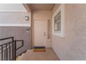 Inviting front door with decorative accents, a welcome mat, and a textured wall exterior at 2325 Windmill Pkwy # 323, Henderson, NV 89074