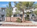 Well-maintained home exterior with landscaped front yard, trees, and brick wall at 3137 Sunrise Cove Ave, North Las Vegas, NV 89031