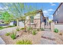 Charming single-story home featuring stone accents, desert landscaping, and a brick paver walkway at 343 American Dipper St, Las Vegas, NV 89138