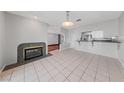 Open-concept living area with fireplace, tile flooring and view to the kitchen at 4272 E Russell Rd, Las Vegas, NV 89120