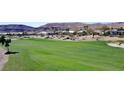 Beautiful golf course featuring vibrant green grass with mountains in the background at 5059 Pensier St, Las Vegas, NV 89135