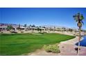 Scenic view of lush green golf course, pond and homes with mountains in background at 5059 Pensier St, Las Vegas, NV 89135