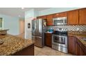 Well-equipped kitchen features stainless steel appliances, granite countertops, and warm wood cabinetry at 5081 Monte Penne Way, Pahrump, NV 89061