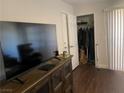 Bedroom features a large window, closet, and wooden floors with a TV stand and television at 5130 S Jones Blvd # 203, Las Vegas, NV 89118