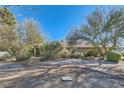 Wide view of the front yard with a stone path, desert landscaping and a partial view of the home at 6925 Donald Nelson Ave, Las Vegas, NV 89131