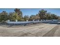 Wide street view showing the property's fence line with trees and partial view of the home at 6925 Donald Nelson Ave, Las Vegas, NV 89131