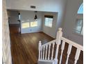 Bright living area with hardwood floors, large windows with shutters, and a modern pendant light fixture above the dining area at 7509 Wheat Grass Ct, Las Vegas, NV 89129