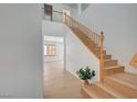 Bright entryway with wood-look floors, soaring ceilings, and an open staircase at 8027 Anasazi Ranch Ave, Las Vegas, NV 89131