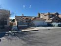 Beige single-story home with garage, and front yard enclosed by a fence at 807 Zinnia Cir, Henderson, NV 89015