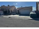 Beige single-story home with garage, and a vehicle parked in the driveway at 807 Zinnia Cir, Henderson, NV 89015