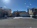 Beige single-story home featuring a garage and a small gated front yard at 807 Zinnia Cir, Henderson, NV 89015