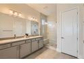 Contemporary bathroom showcasing double sinks, sleek cabinetry, and a glass-enclosed shower with a built-in seat at 10026 Honey Rose Ave, Las Vegas, NV 89143