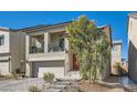 Inviting two-story home featuring a balcony, stone steps to the front door, and desert landscaping at 10393 Rose Palisade St, Las Vegas, NV 89141