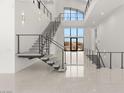 Grand staircase with modern railings and abundant natural light from the large windows at 1057 Giovanni Ln, Henderson, NV 89012