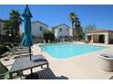 Community pool with lounge chairs, tables, and palm trees for a relaxing atmosphere at 1286 Horizon Village Ave, Las Vegas, NV 89183