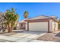 Attractive single-story home with a two-car garage, desert landscaping, and tile roof at 427 Mindoro Ave, North Las Vegas, NV 89031
