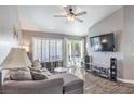Comfortable living room featuring a modern ceiling fan, plush sectional, and hardwood floors at 427 Mindoro Ave, North Las Vegas, NV 89031