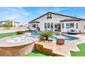 A backyard paradise with a custom pool, spa, and elegant patio furniture, perfect for relaxation and entertaining at 6392 Ebony Legends Ave, Las Vegas, NV 89131