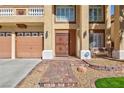 Inviting front entrance with secure door, brick steps, manicured lawn, and beautiful desert landscaping at 6578 Chimes Tower Ave, Las Vegas, NV 89139