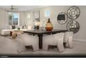 Elegant dining area with a dark wood table, comfortable seating, and modern artwork complementing the adjacent living space at 6818 Sweet Bay St # Lot 11, Las Vegas, NV 89166