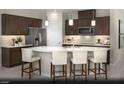 Modern kitchen with dark cabinetry, stainless steel appliances, and a large center island with white countertop and seating at 6818 Sweet Bay St # Lot 11, Las Vegas, NV 89166