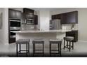 Modern kitchen with granite countertops, stainless steel appliances, and stylish dark cabinetry at 6826 Sweet Bay St # Lot 10, Las Vegas, NV 89166