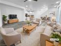 Bright, open-concept living room with modern furnishings and gray wood-look flooring at 7059 Mackenzie Bay Ave, Las Vegas, NV 89179