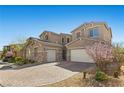 Charming two-story home boasts a stone accent, attached two car garage and a beautifully landscaped front yard at 8895 Dartmouth Grove Ave, Las Vegas, NV 89148