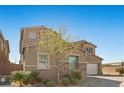 Charming two-story home boasts a stone accent, attached one car garage and a beautifully landscaped front yard at 8895 Dartmouth Grove Ave, Las Vegas, NV 89148