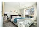 Bright main bedroom with a ceiling fan, a large window, and neutral decor at 9858 Gemstone Sunset Ave, Las Vegas, NV 89148