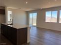 Open-concept kitchen features a center island, stainless steel appliances, sliding glass doors and mountain views at 10012 River Corral St, Las Vegas, NV 89166