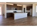 Kitchen with island, quartz countertops, stainless appliances and dark brown cabinets at 10012 River Corral St, Las Vegas, NV 89166