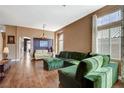 Bright living room with hardwood floors, comfortable sofas, and large windows offering natural light at 10532 Beachwalk Pl, Las Vegas, NV 89144